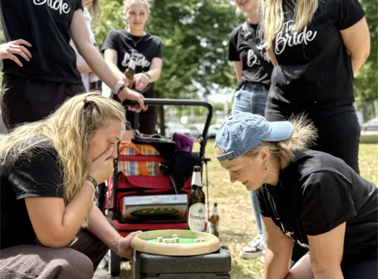 Bierwanderung-Willingen-Bierrallye-Sauerland-Bierbike-JGA Mädels auf Junggesellenabschied während des JGA-Events in Venlo mit der Eventagentur "Deine Erlebnismacher", die sich auf Bierwanderung beim Spiel “Summenprinzessin“ mit Würfeln duellieren.