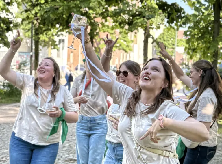 Tanzende Frauen auf einem JGA in Düsseldorf mit Weingläsern in der Hand.