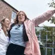 Junggesellinnenabschied mit der Braut und ihrer Freundin, die Weingläser in den Händen halten und tanzen.