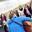 Gitarrist mit Gitarre am Ufer vom Fluss Maas in Venlo mit Frauen auf einem Junggesellenabschied.