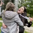 Zwei Frauen auf einem JGA Event Weinwanderung, die sich tanzend in den Armen liegen.