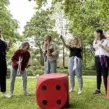 JGA Event in Paderborn bei dem Frauen im Park ein Spiel mit einem riesigen Würfel spielen.