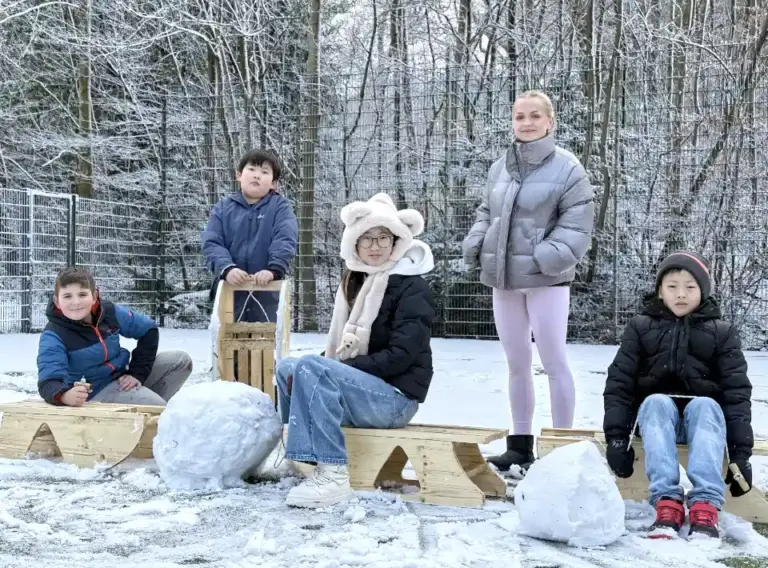 Winterferien-Ferienbetreuung mit kreativen Outdoor-Erlebnissen –Deine Erlebnismacher Kinder und Jugendliche bauen selbstgefertigte Holzschlitten und spielen im Schnee bei der Winterferien-Ferienbetreuung von deine Erlebnismacher
