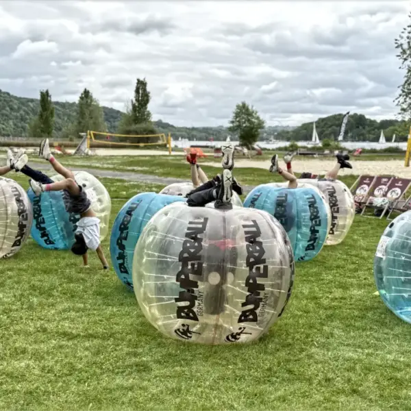 Kinder in Bubble Soccer Bällen auf dem Kopf stehend beim Kindergeburtstag am Seaside Beach Baldeney in Essen