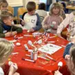Kinder auf Ferienfreizeit an einem Basteltisch die Eier zu Ostern bemalen im Seminarraum der DJH Essen-Werden