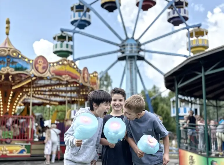 Ferienfreizeit-Sommerferien-2026 Kinder auf Ferienfreizeit Sommerferien 2026 im Freizeitpark Schloss Beck mit Zuckerwatten in den Händen.