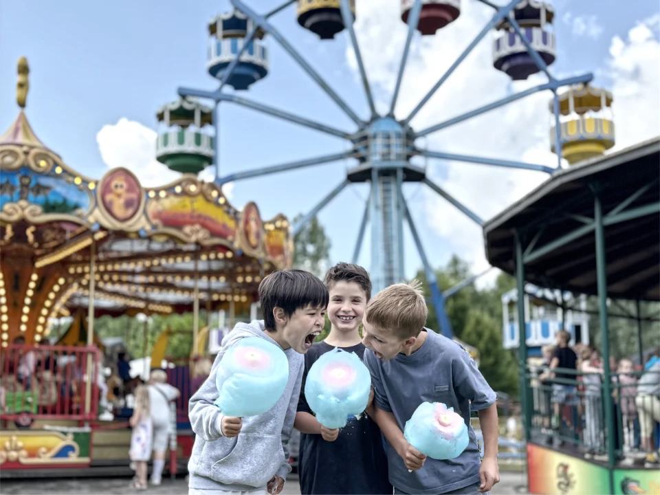 Kinder im Freizeitpark Schloss Beck mit Zuckerwatten in den Händen, beim Tagesausflug während der Ferienbetreuung Essen von der Agentur Deine Erlebnismacher.