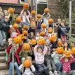 Kinder auf Ferienfreizeit bei Deine Erlebnismacher aus Essen mit selbstgeschnitzten Kürbissen in den Händen vor der DJH Jugendherberge Essen.