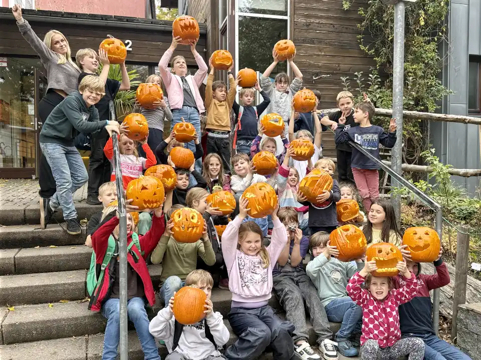 Kinder auf Ferienfreizeit bei Deine Erlebnismacher aus Essen mit selbstgeschnitzten Kürbissen in den Händen vor der DJH Jugendherberge Essen.