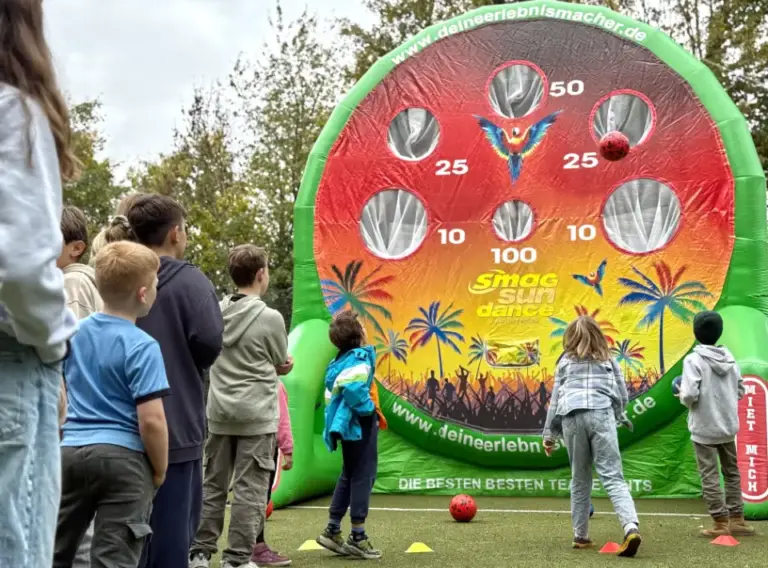 Ferienfreizeit-Herbst-Herbstferien-Freizeit-Ferienbetreuung Kinder auf Ferienfreizeit in Essen bei Deine Erlebnismacher, die an einer aufgeblasenen, riesigen Torwand spielen.