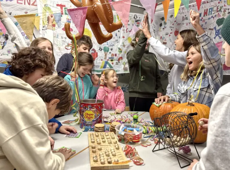 Ferienfreizeit-Herbst-Herbstferien-Freizeit-Ferienbetreuung-Bingo Jubelnde Kinder beim Spiel Bingo auf Herbstferien-Freizeit bei Deine Erlebnismacher in Essen.