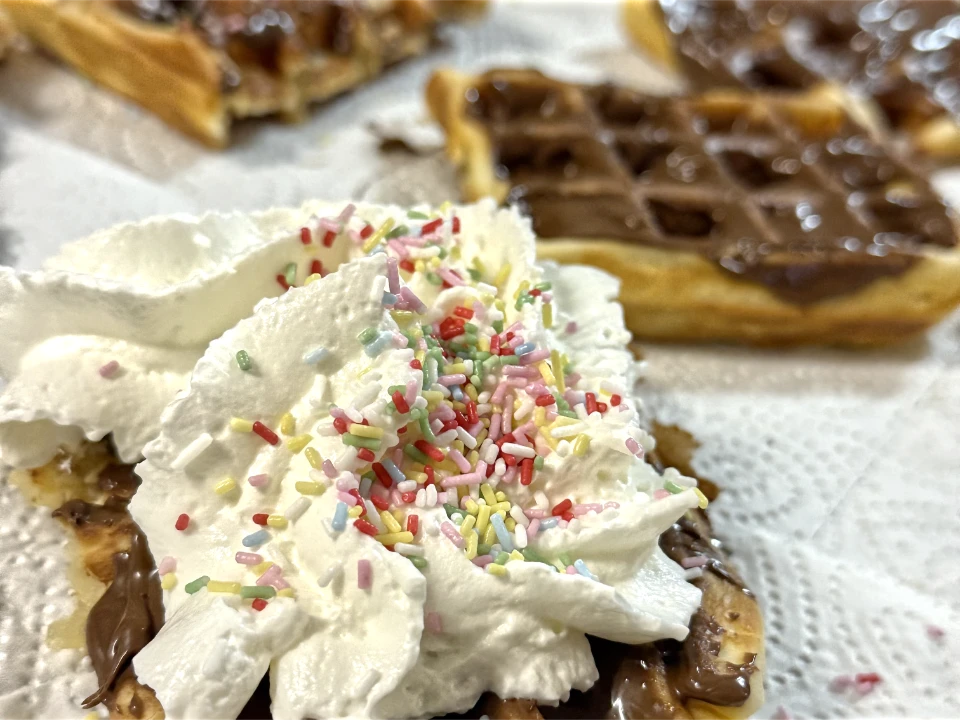 Selbstgemachte Waffeln mit Sahne, Nutella und Streuseln.