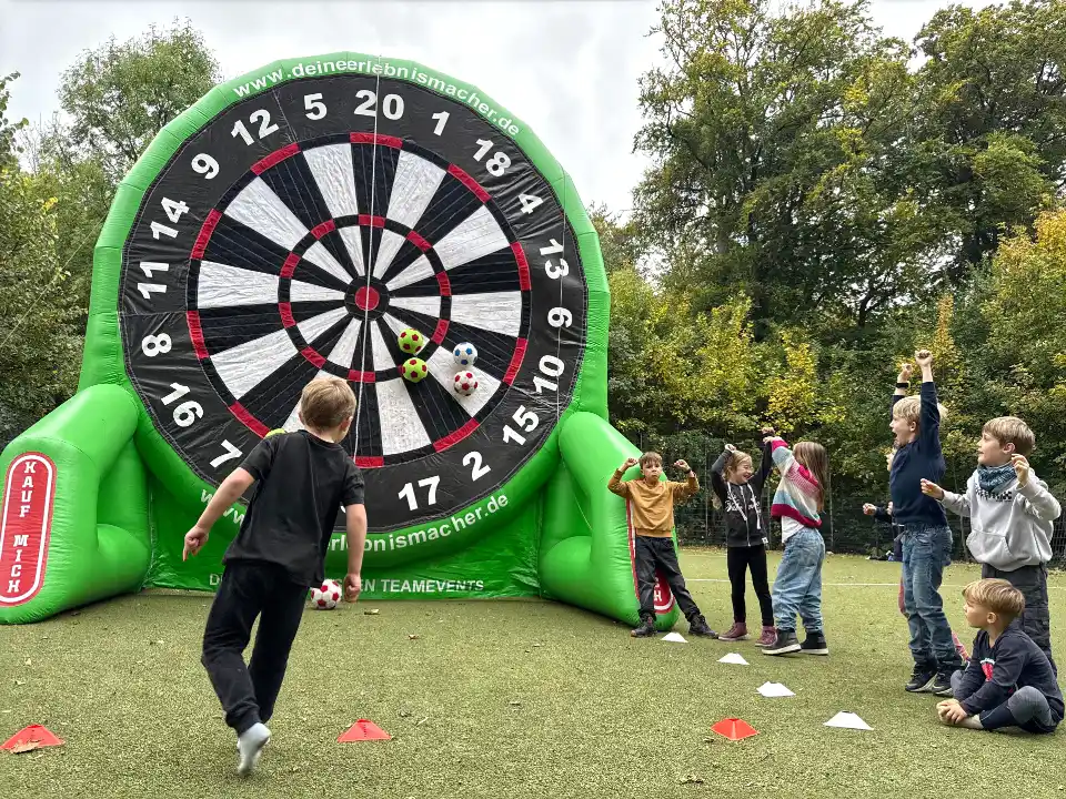 Kinder auf Ferienfreizeit bei Deine Erlebnismacher aus Essen beim Spielen am aufblasbaren Fußball Darts Modul