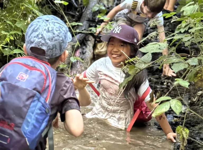 Ferienfreizeit Sommerferien-Ferienbetreuung Sommerferien-Feriencamp Essen-Waldauflug Kinder im Wasser eines Baches auf Waldexpedition bei der Ferienfreizeit in Essen von Deine Erlebnismacher.