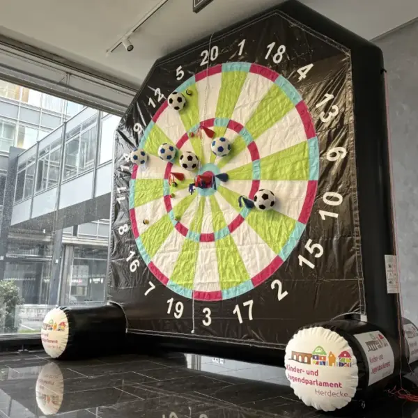 Fußball-Dart eckig 4 m – individuelles Event-Modul mit Klettbällen | Deine Erlebnismacher Aufblasbares Fußball-Dart-Modul in eckiger Form, 4 Meter hoch, individuell gestaltet für die Stadt Herdecke, mit Klett-Fußbällen und Filz-Wurfpfeilen, hergestellt von Deine Erlebnismacher