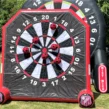 Rotes Fußball-Darts mit Luft befüllt und einer Klettwand mit Klettbällen