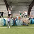 Eine Gruppe von Menschen posiert für ein Foto in aufblasbaren Bumper Balls auf einer Wiese.