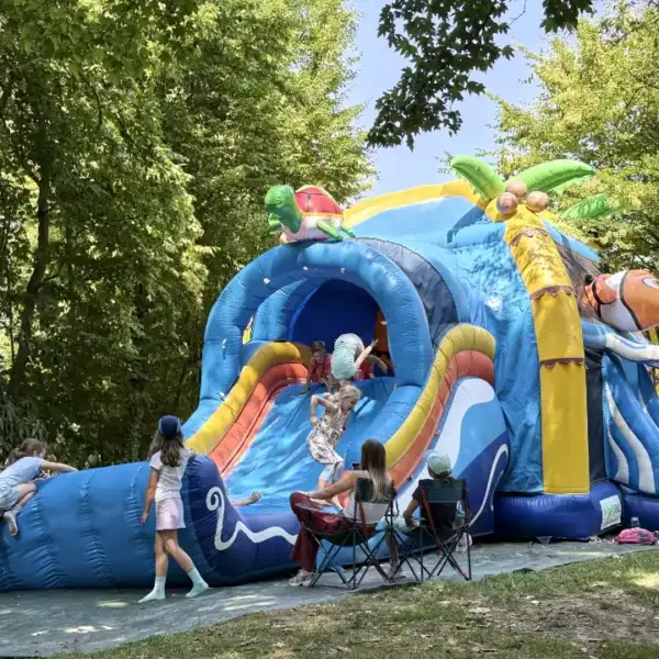 Spielende Kinder auf einer riesigen Hüpfburg mit XXL-Wasserrutsche aufgeblasen auf dem Gelände der DJH Jugendherberge in Essen Werden.