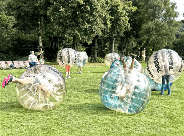 Kindergeburtstag-Ideen-Mädchen Kinder beim Bumperball Spiel in aufgeblasenen Luftkugeln.