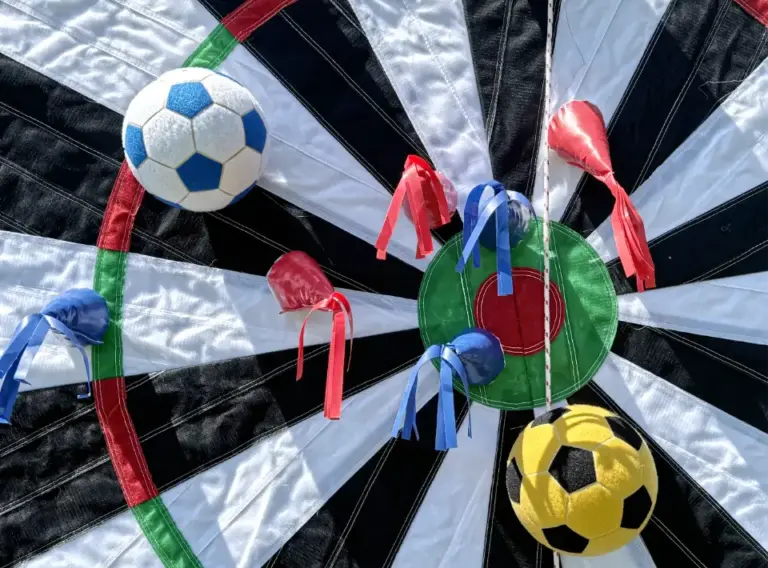 Klettball-Filzball-Klettpfeil-Fußballdarts-Darts Zwei Klettbaelle und fünf Wurfpfeile aus Klett haften auf einer Dartswand aus Klett