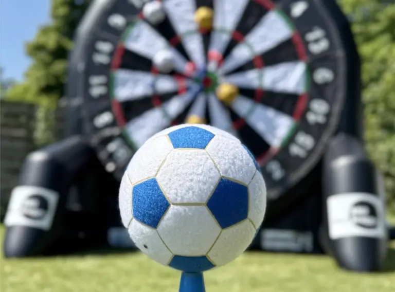 Klettball-Klettbaelle-blau-weiß-Fußballdarts-Klettwand Klettball aus Filz in den Farben blau und weiß vor einem aufgeblasenen Fußball Darts