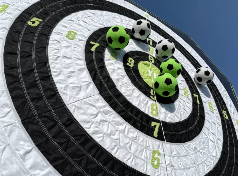 Klettball-Klettbaelle-Filzball 3 schwarz-weiße Klettbälle und 3 gruen-schwarze Klettbälle auf einer Klettwand mit Punkten von 5 bis 10