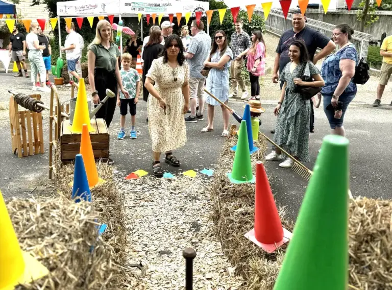 Sommerfest-Firmenfeier-Firmenfest-Teambuilding-Westerncity-Hufeisenwerfen-Wurfspiel-Hufeisenspiel Frau beim Spiel "Hufeneisenwerfen" auf der Firmenfeier als Jahrmarkt-Event.
