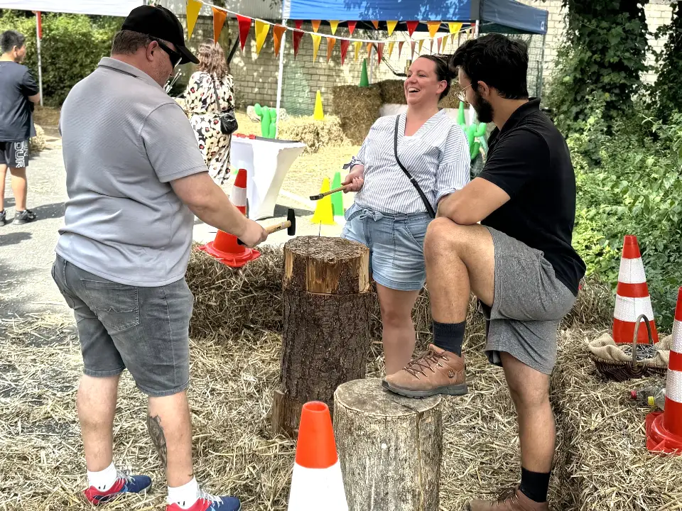 Menschen am Nagelbock auf dem Sommerfest "Jahrmarkt".