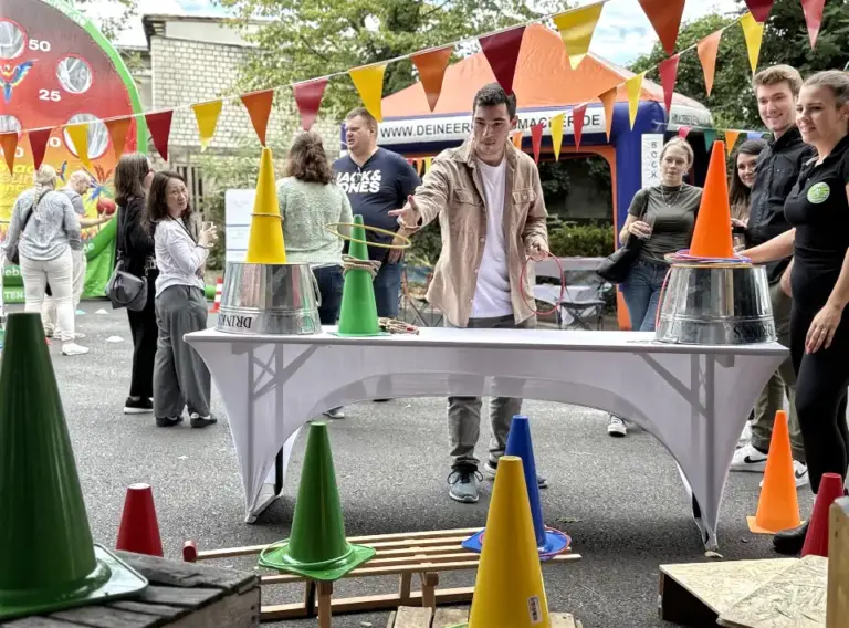Sommerfest-Jahrmarkt-Teambuilding-Event-Firmenfeier-Ringewerfen-Kirmesstand-mieten Junger Mann beim Ringewerfen auf der Firmenfeier vom Sommerfest der Firma Moldino in Hilden.