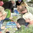 Menschen auf Firmenfeier mit der Eventagentur "Deine Erlebnismacher" während des Teambuilding-Event Schnitzeljagd beim Puzzeln.