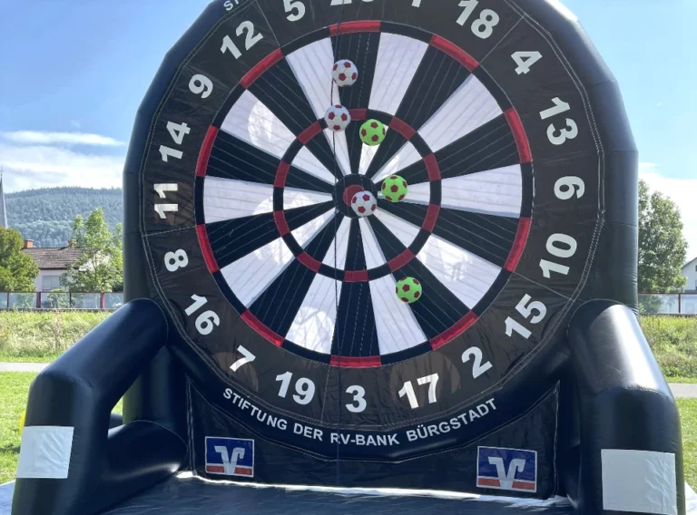 Verkauf-Fußballdarts-Fussballdart-Kaufen-Fußball-Dart-Torwand-Volksbank-Bürgstadt Schwarzes Fußball Darts mit Klettwand und Klettbällen aufgeblasen auf einer Plane stehend