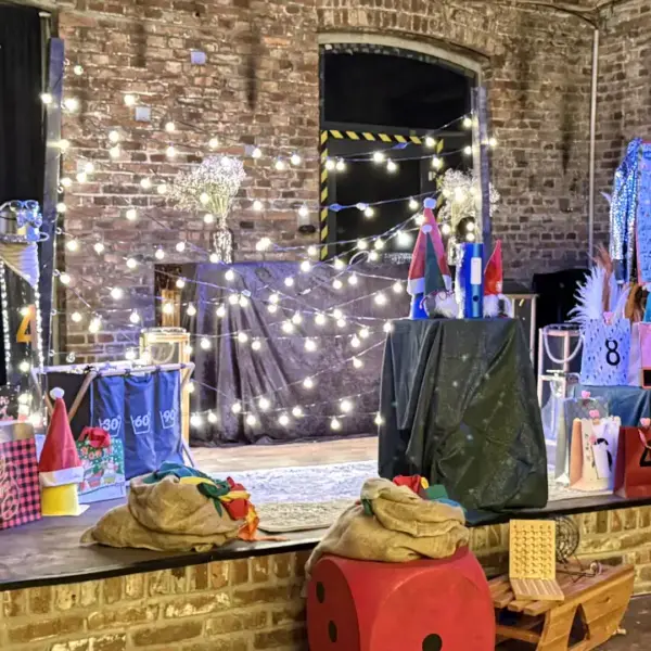 Weihnachtsfeier QuizShow Bühne – Interaktives Teambuilding Event im Winter Bühnenaufbau einer Weihnachtsfeier QuizShow mit Spielstationen, Lichterketten und Teambuilding-Elementen.