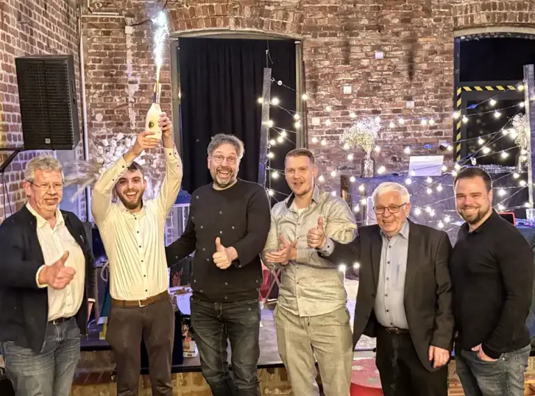 Weihnachtsfeier QuizShow mit Spieleklassikern der 90er – Interaktives Teambuilding Event Teilnehmer einer Weihnachtsfeier QuizShow mit Spielen aus den 90ern und interaktiven Raterunden als Teambuilding Event.