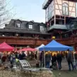 Wintermarkt-Location mit Pavillons, Lichterketten und Gästen bei einer weihnachtlichen Firmenfeier und Winterolympiade.