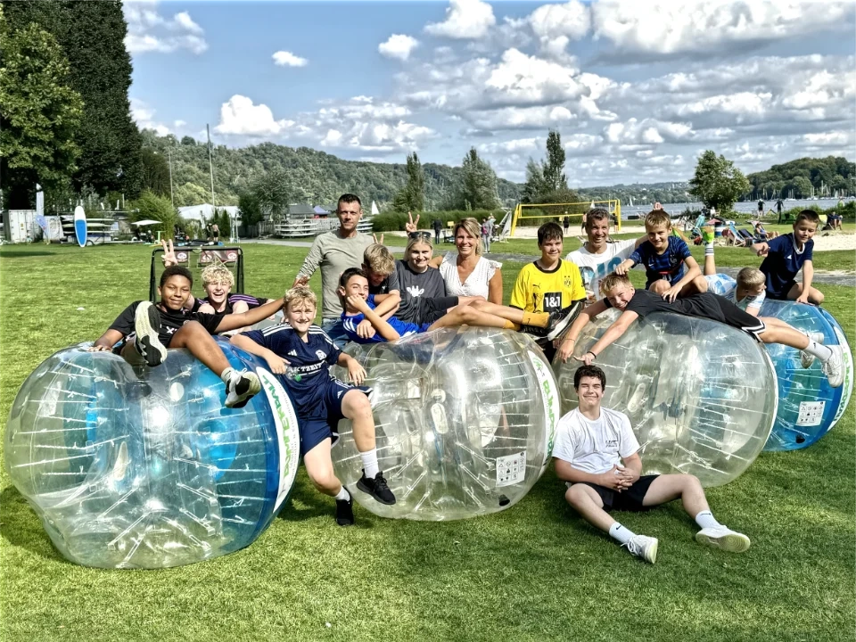Kinder beim Bumper Ball Kindergeburtstag mit aufblasbaren Bubble Soccer Bällen am Seaside Beach Baldeneysee in Essen