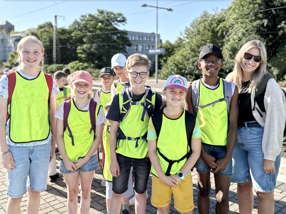 Kinder und Betreuerin der Ferienfreizeit Sommerferien in Essen am Bahnhof auf dem Weg zum Tagesausflug in den Freizeitpark Schloss Beck