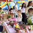 Kinder basteln Perlenarmbänder und Hawaii-Ketten an einer Bastelstation beim Sommerfest