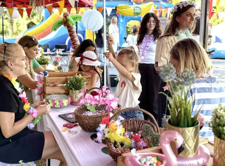 Bastelstation & Kinderprogramm beim Firmen-Sommerfest Kinder basteln Perlenarmbänder und Hawaii-Ketten an einer Bastelstation beim Sommerfest