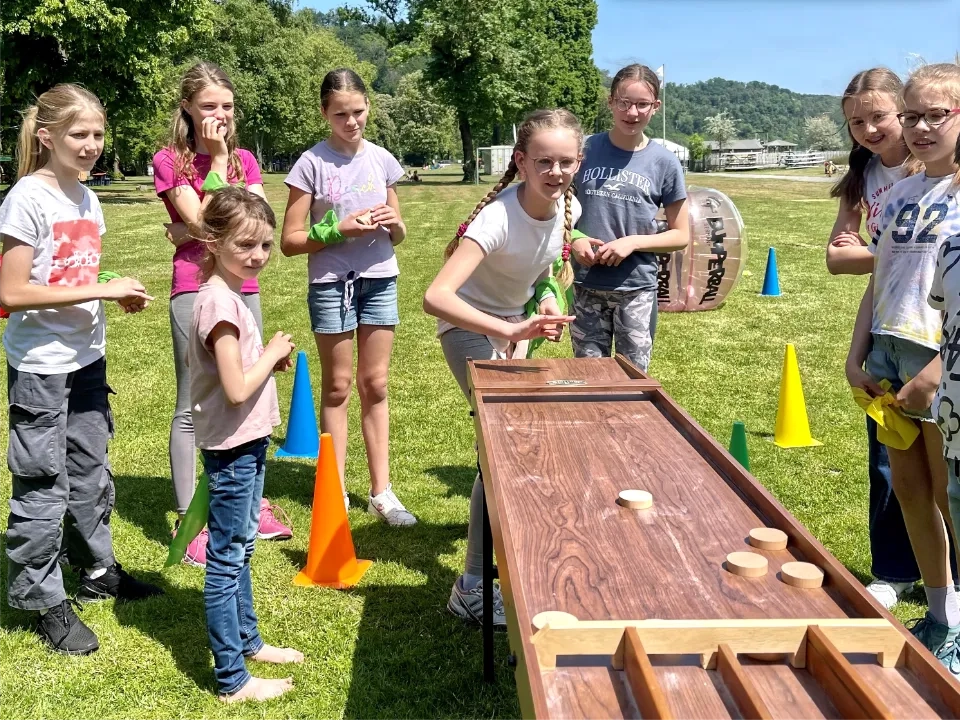 Kinder spielen Shuffleboard bei einer Mini-Olympiade zum Kindergeburtstag in Essen am Seaside Beach Baldeneysee.