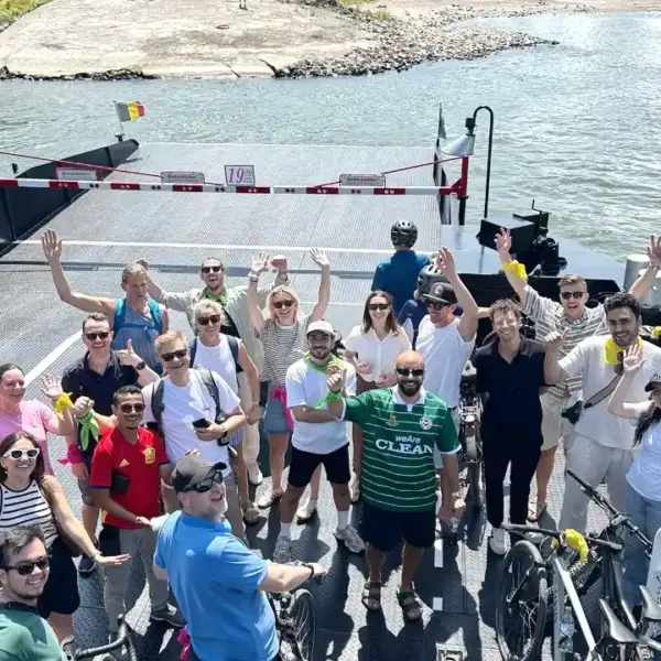 Teilnehmer einer betreuten Fahrradrallye für Unternehmen auf der Rheinfähre zwischen Düsseldorf-Kaiserswerth und Meerbusch während eines Sommerfestes mit interaktiven Teamspielen und geführter Fahrradtour