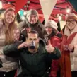 Teilnehmer einer Glühweinwanderung stoßen bei einer winterlichen Weihnachtsfeier gemeinsam an und genießen Glühwein als Team-Event