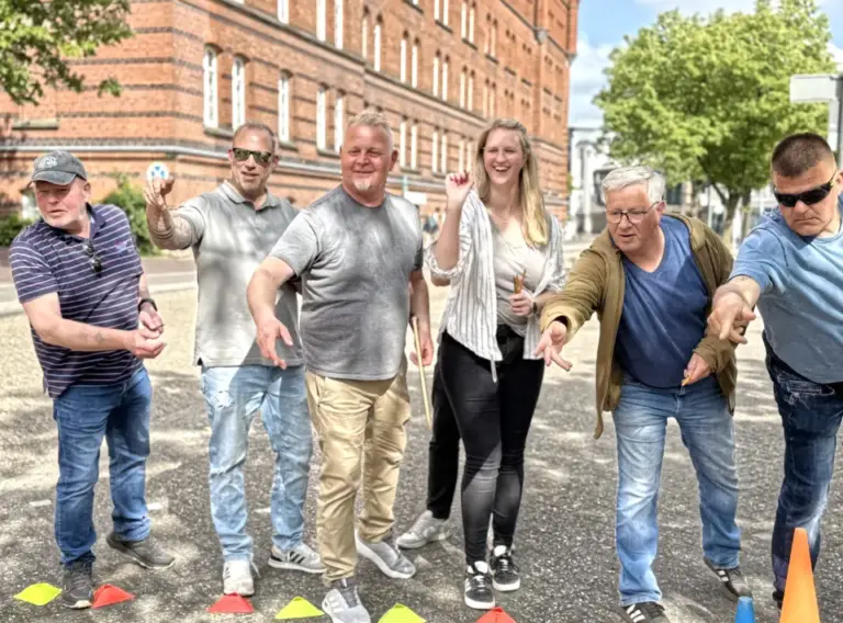 Sommerfest-Teambuilding-Firmenfeier-Teamspiele-Mini-Olympiade Frauen und Männer auf einer Firmenfeier in Oldenburg, die an einem Event teilnehmen und Stifte werfen.