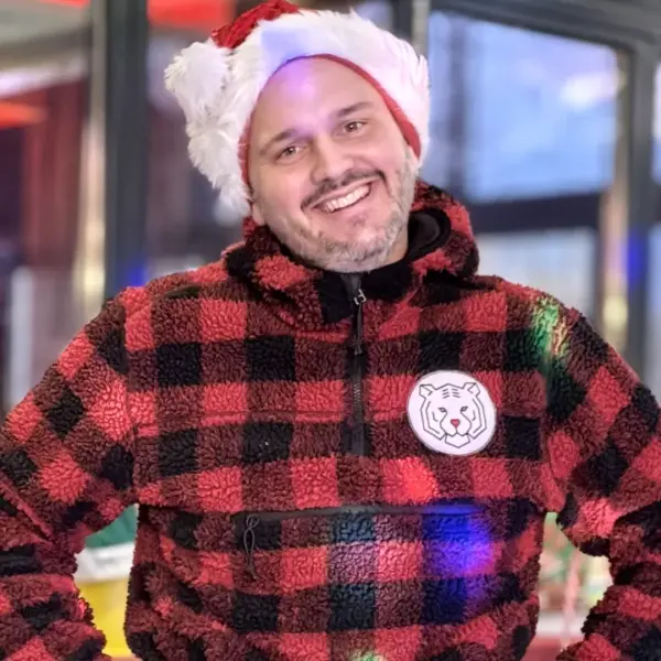 Weihnachtsfeier-Ideen: Erlebnismacher Eventleiter in winterlicher Kleidung bei der Betreuung einer Firmenweihnachtsfeier