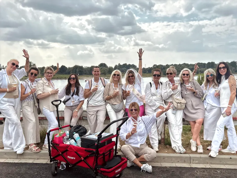 Junggesellenabschied Weinwanderung Düsseldorf mit Mädels-JGA-Gruppe beim gemeinsamen Anstoßen am Rheinufer.