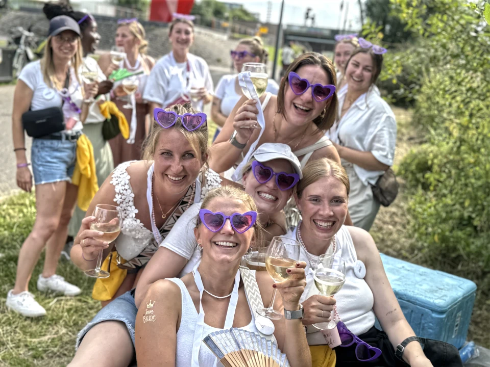 Junggesellenabschied bei einer Weinwanderung in einer deutschen Stadt mit lachender Gruppe und Weingläsern