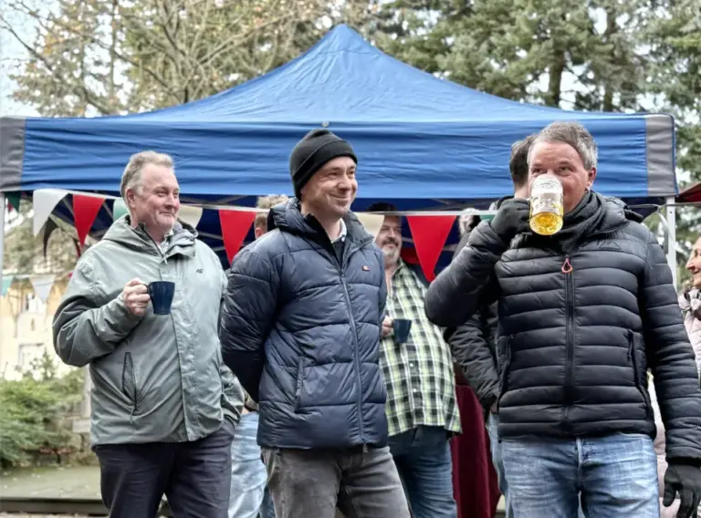 Firmenweihnachtsfeier auf einem mobilen Weihnachtsmarkt Mitarbeitende genießen Getränke auf einer Firmenweihnachtsfeier als mobiler Weihnachtsmarkt im Freien