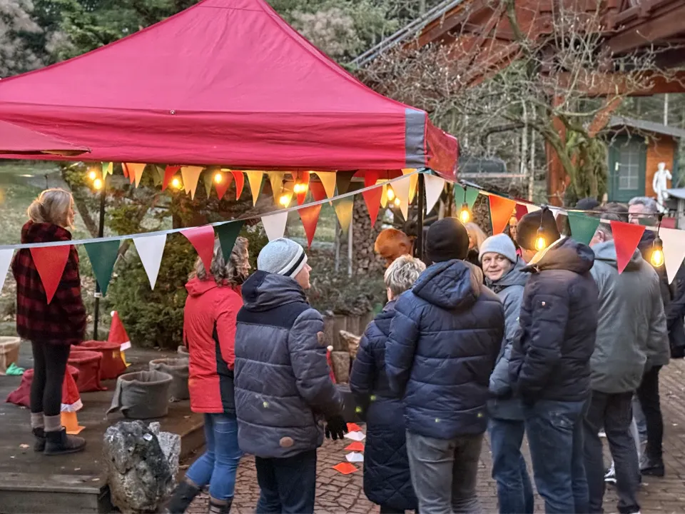 Mobiler Weihnachtsmarkt für Firmen mit Weihnachtshütten, Lichterketten und Mitarbeitenden auf einer Firmenweihnachtsfeier