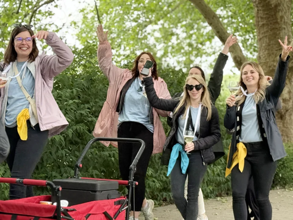 Sommerfest Firma Weinrallye Team läuft mit Bollerwagen und Wein durch Park Teamevent Outdoor