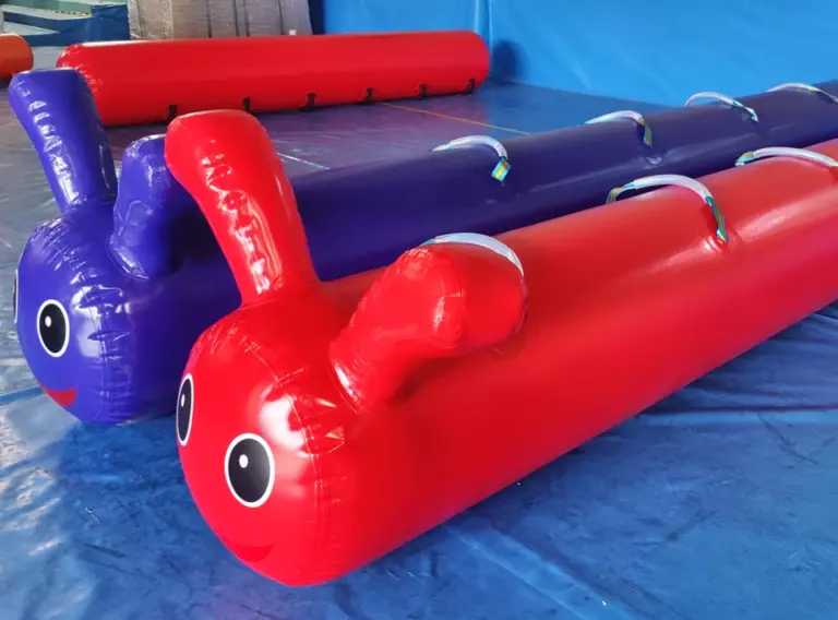 Aufblasbare Teamraupe in Rot und Blau als individuelles Teambuilding Eventmodul für Firmen, Sommerfeste und Teamveranstaltungen.