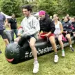 Teilnehmer nutzen eine aufblasbare Teamraupe bei einem Teambuilding Firmenevent und fördern gemeinsam Teamgeist, Kommunikation und Zusammenarbeit.
